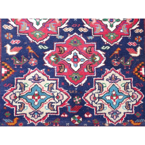 1531 - Carpet / Rug : A rug with blue ground and cream ground border, decorated with geometric vignettes an... 