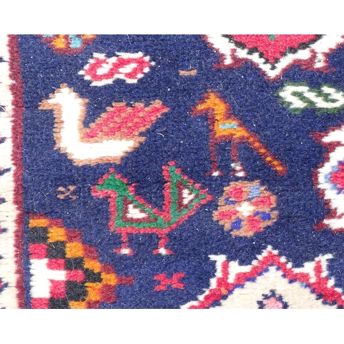 1531 - Carpet / Rug : A rug with blue ground and cream ground border, decorated with geometric vignettes an... 