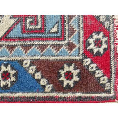 1533 - Carpet / Rug : A runner with pale blue ground with banded geometric red, brown and bright blue detai... 