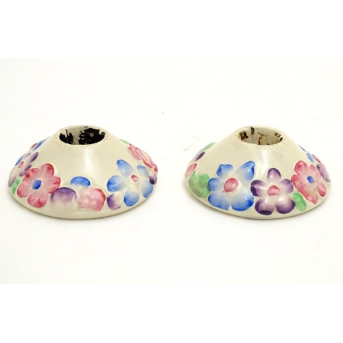 106 - A pair of Clarice Cliff candle holders from the My Garden Verdant series with relief floral decorati... 