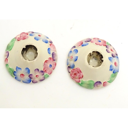 106 - A pair of Clarice Cliff candle holders from the My Garden Verdant series with relief floral decorati... 