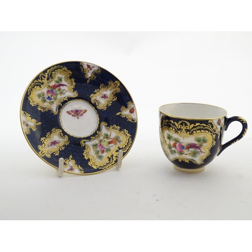 110 - A Royal Worcester tea cup and saucer decorated blue scale ground and vignette panels hand painted wi... 