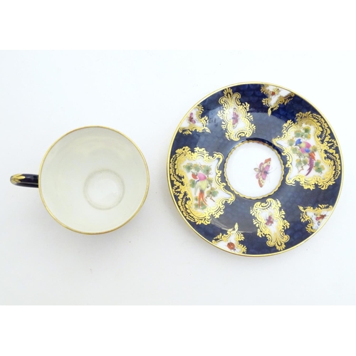 110 - A Royal Worcester tea cup and saucer decorated blue scale ground and vignette panels hand painted wi... 