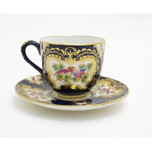 110 - A Royal Worcester tea cup and saucer decorated blue scale ground and vignette panels hand painted wi... 