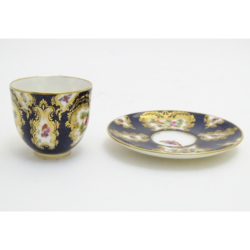 110 - A Royal Worcester tea cup and saucer decorated blue scale ground and vignette panels hand painted wi... 