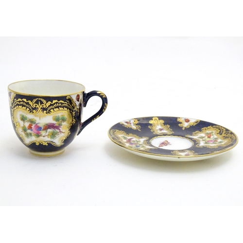 110 - A Royal Worcester tea cup and saucer decorated blue scale ground and vignette panels hand painted wi... 