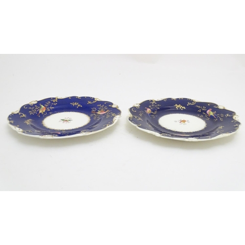 112 - Two 19thC dessert plates with cobalt blue ground scrolling gilt highlights and hand painted bird and... 