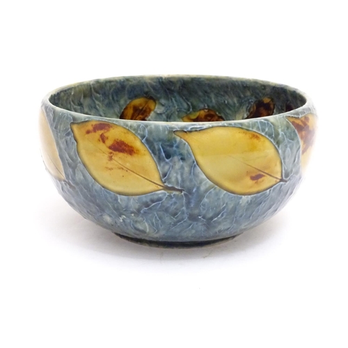 114 - A Royal Doulton stoneware bowl with banded autumnal foliate leaf decoration on a mottled blue ground... 