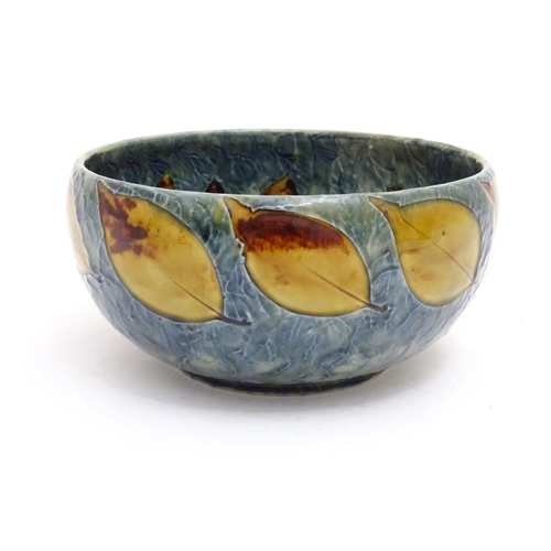 114 - A Royal Doulton stoneware bowl with banded autumnal foliate leaf decoration on a mottled blue ground... 