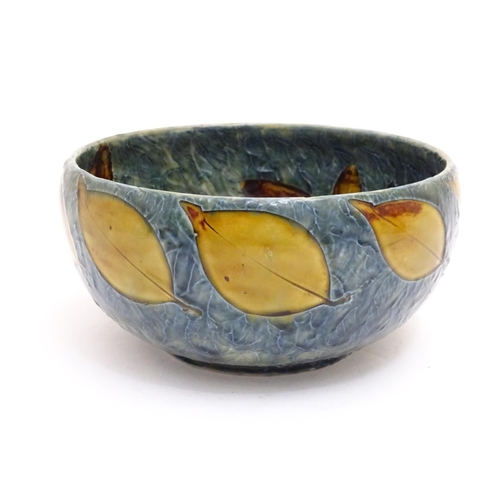 114 - A Royal Doulton stoneware bowl with banded autumnal foliate leaf decoration on a mottled blue ground... 