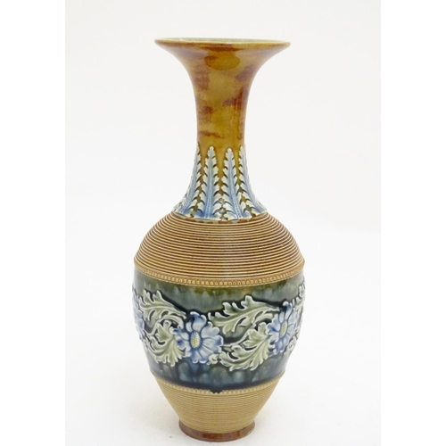 115 - A Doulton Lambeth stoneware vase with a flared rim, ribbed body and banded section with scrolling fl... 