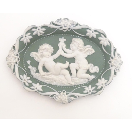 124 - A matched pair of Continental oval wall plaques with jasperware style decoration with putti, flowers... 