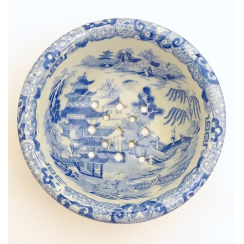 129 - A 19thC blue and white small strainer, decorated with an Oriental landscape scene with pagodas etc. ... 