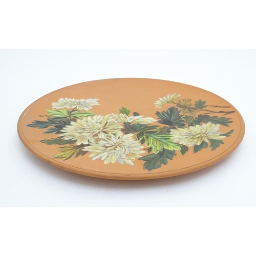 166 - A Longpark Torquay terracotta charger with chrysanthemum flower decoration. Impressed mark and indis... 