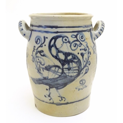 181 - A stoneware crock pot of ovoid form with twin handles and hand painted bird and scrolling foliage de... 