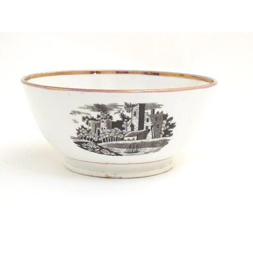 65 - A 19thC bowl with monochrome transfer decoration depicting a river landscape with a ship and castle ... 