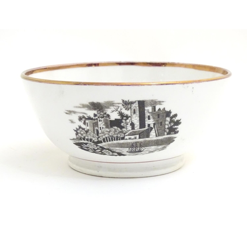 65 - A 19thC bowl with monochrome transfer decoration depicting a river landscape with a ship and castle ... 