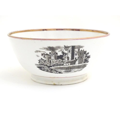 65 - A 19thC bowl with monochrome transfer decoration depicting a river landscape with a ship and castle ... 