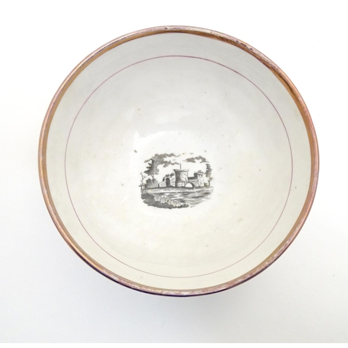 65 - A 19thC bowl with monochrome transfer decoration depicting a river landscape with a ship and castle ... 