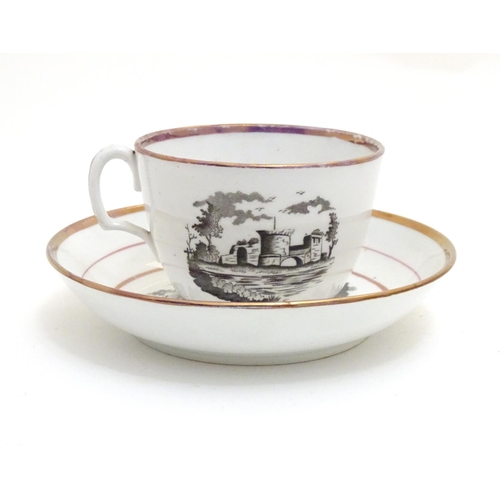 66 - A 19thC tea cup and saucer with monochrome transfer decoration depicting a river landscape with a sh... 