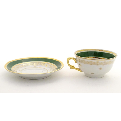 69 - A French tea cup and saucer depicting Emperor Napoleon with green and gilt highlights. Porcelaine de... 