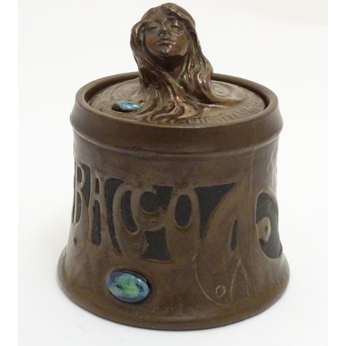 74 - A Bretby Art Nouveau tobacco pot with faux hammered copper effect and enamelled cabochon detail. The... 