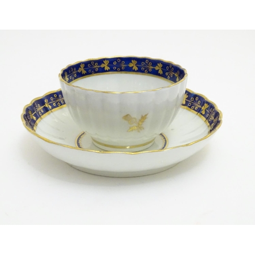 80 - A Fight & Barr Worcester fluted tea bowl and saucer with gilt thistle motifs and a blue and gilt bor... 