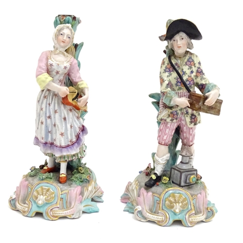 83 - A pair of 19thC Continental figural candlesticks, modelled as a man with a wooden box and lantern, a... 