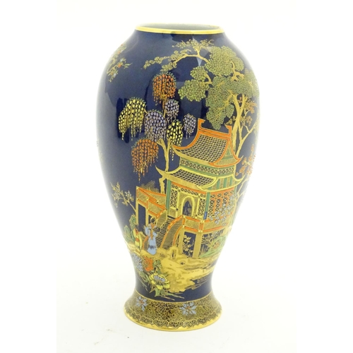 99 - A Wiltshaw and Robinson Carlton Ware baluster vase decorated with a landscape scene with pagodas, br... 