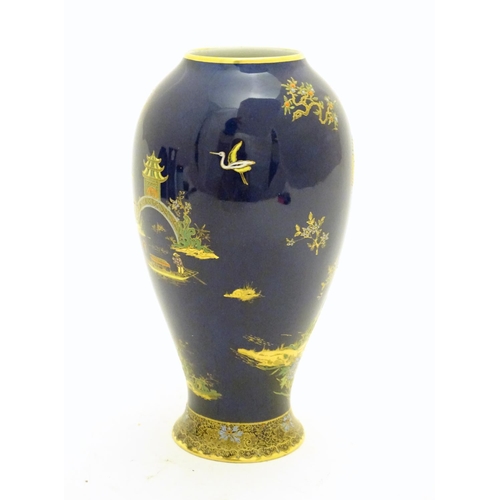 99 - A Wiltshaw and Robinson Carlton Ware baluster vase decorated with a landscape scene with pagodas, br... 