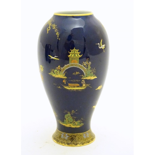 99 - A Wiltshaw and Robinson Carlton Ware baluster vase decorated with a landscape scene with pagodas, br... 