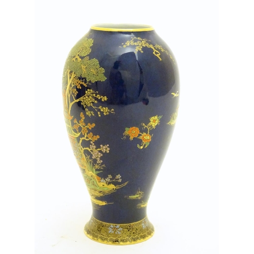 99 - A Wiltshaw and Robinson Carlton Ware baluster vase decorated with a landscape scene with pagodas, br... 