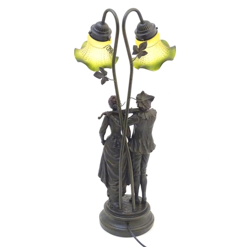 1518 - A late 20thC / 21stC table lamp with figural decoration and twin branches wit green glass shade Appr... 