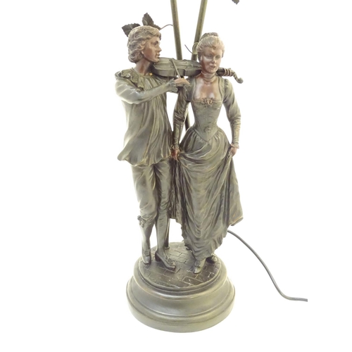 1518 - A late 20thC / 21stC table lamp with figural decoration and twin branches wit green glass shade Appr... 