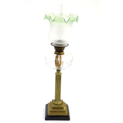 1519 - A late 19thC / early 20thC oil lamp, the brass column on stepped base supporting a clear cut glass r... 