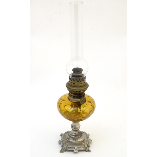 1523 - A late 19thC / early 20thC Continental oil lamp wit amber glass reservoir and clear glass chimney. T... 