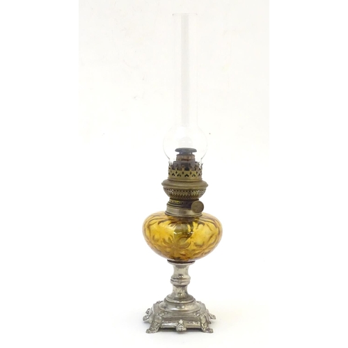 1523 - A late 19thC / early 20thC Continental oil lamp wit amber glass reservoir and clear glass chimney. T... 