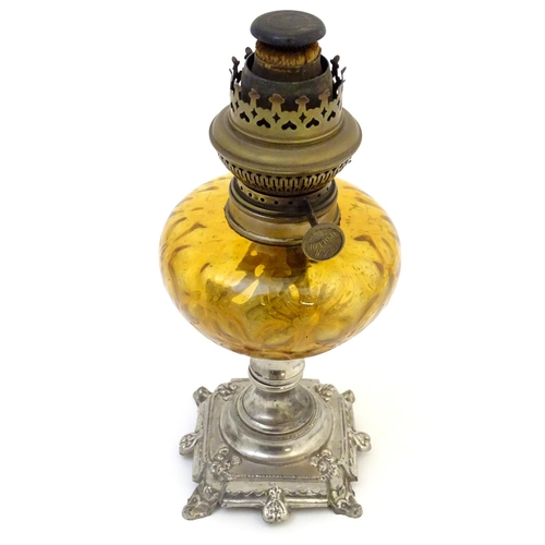 1523 - A late 19thC / early 20thC Continental oil lamp wit amber glass reservoir and clear glass chimney. T... 