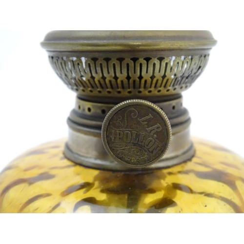 1523 - A late 19thC / early 20thC Continental oil lamp wit amber glass reservoir and clear glass chimney. T... 