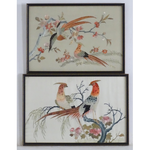 1761 - Two oriental silk embroideries depicting stylised golden pheasant birds perched on branches, with fl... 