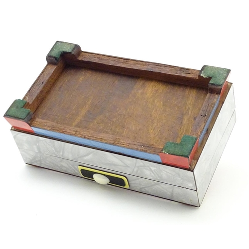 844 - An Art Deco box with a hinged lid with formica veneers and celluloid roundels etc. Approx. 4 1/4