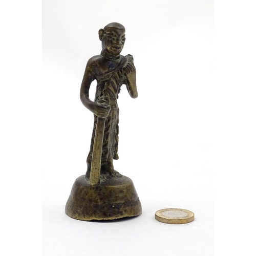 847 - An Oriental brass figure modelled as a man with a staff. Approx. 4 1/2