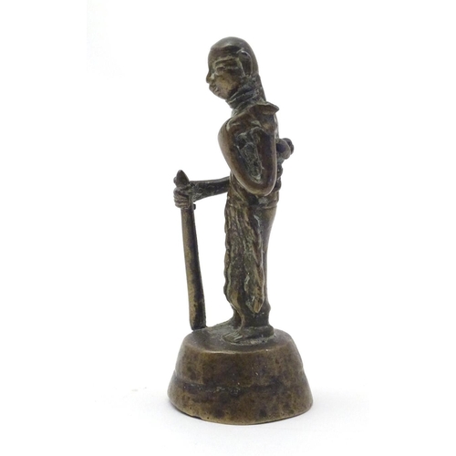 847 - An Oriental brass figure modelled as a man with a staff. Approx. 4 1/2