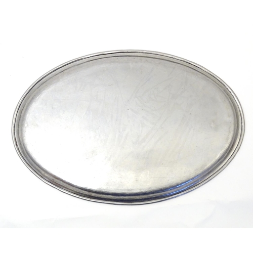 813 - An early 20thC Hugh Wallis oval hammered tray. Stamped with HW monogram. Approx. 13 1/4