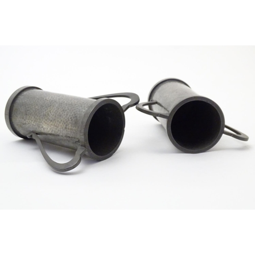 817 - A pair of Arts & Crafts pewter vases of cylindrical form with twin handles and hammered decoration b... 