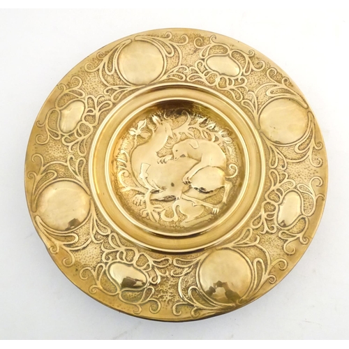 820 - An Arts Nouveau brass charger with hammered detail, the central section with embossed stylised deerh... 