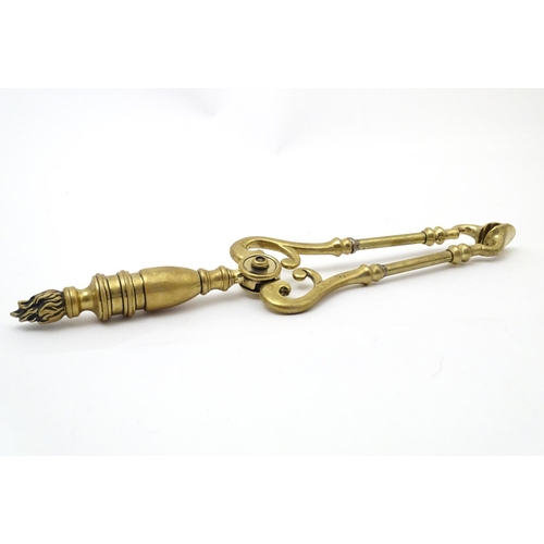 821 - Victorian brass fire tongs with flame finial. Approx. 17