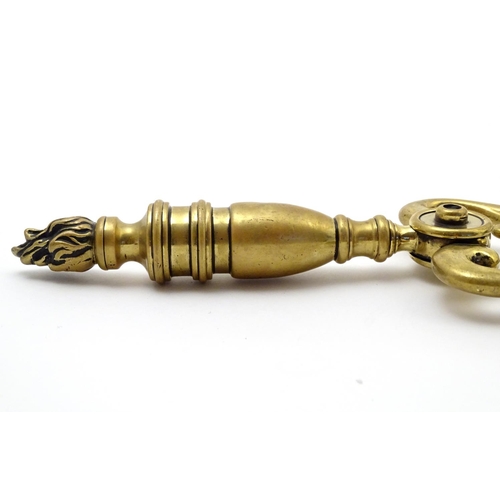 821 - Victorian brass fire tongs with flame finial. Approx. 17