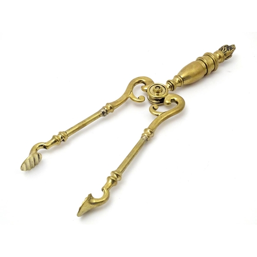 821 - Victorian brass fire tongs with flame finial. Approx. 17