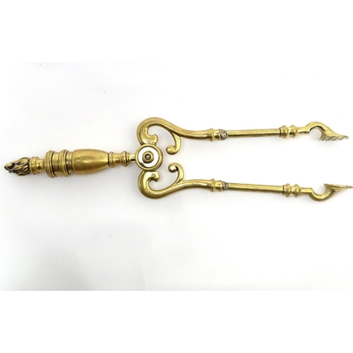 821 - Victorian brass fire tongs with flame finial. Approx. 17